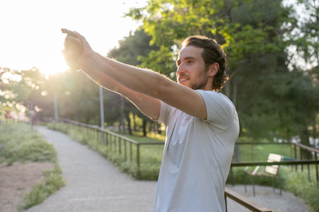 Man stretching in park during sunsetの写真素材