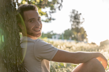 Close-up portrait of a man smiling on a sunny afternoon in the parkの写真素材
