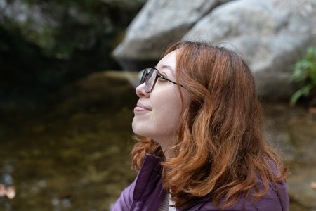 Woman with red hair smiling looking up daydreaming