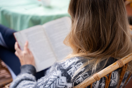 Woman enjoying a cozy moment reading a book indoorsの写真素材