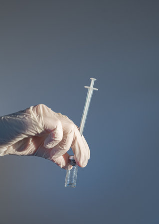 Healthcare professional preparing a vial for injection