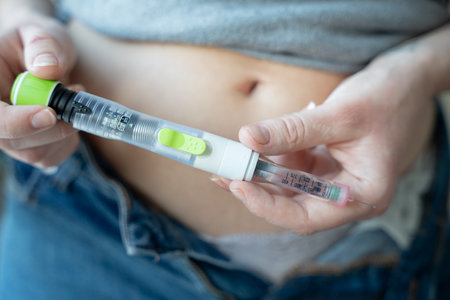 Person injecting insulin with pen for diabetes managementの写真素材