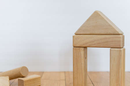 Wooden blocks on a wooden floor with a white background building a house.の写真素材