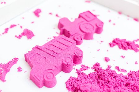 Truck and train made with a pink kinetic sand on a white background.の写真素材