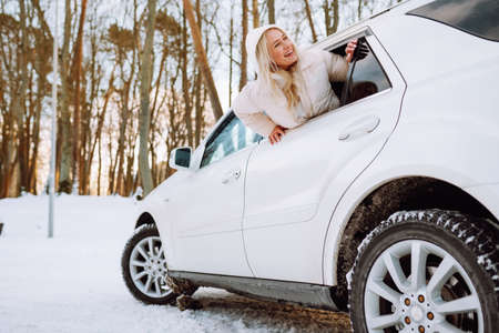 Young blonde woman sit in her new white car and smile happy. Insurance, safety, rent a car.の写真素材