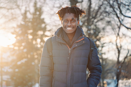 Portrait of smiling black african man. Young guy at city street look at camera amd smile