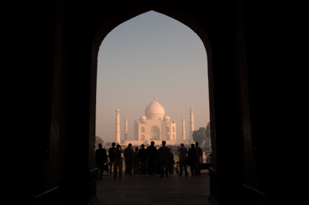 Agra, India - February 6, 2011: Tourists admire Taj Mahal from it's entrance on an early morning. Taj Mahal ,regarded by many as the world's most beautiful tomb, was built by Mughal emperor Shah Jahan in memory of his third wife, Mumtaz Mahal.のeditorial素材