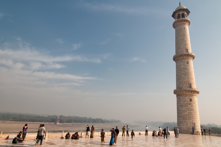 Agra, India - February 6, 2011: Tourists admire one of the minarets of Taj Mahal. The minarets intentionally tilt slightly away from Taj Mahal tomb so that they will fall away from the tomb if they collapse.のeditorial素材