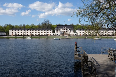 Stockholm, Sweden - May 11, 2013: Young woman fishing on a sunny spring afternoon at Kungsholms Strand in Stockholm with Karlberg palace in the background. のeditorial素材