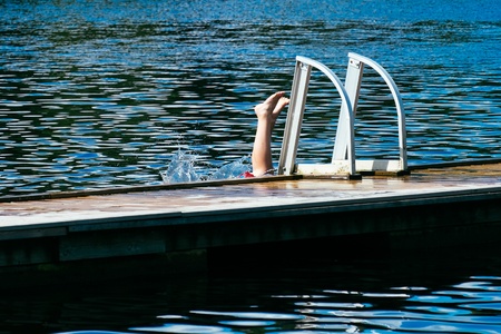 Upside down - a youngster takes a dive and splashes into a lake in Swedenの写真素材