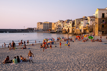 Cefalu, Sicily, Italy - July 16, 2013  Tourists enjoy the beach in Cefalu at sunset.  Cefalu is one of the most popular destinations for a Sicilian vacation のeditorial素材