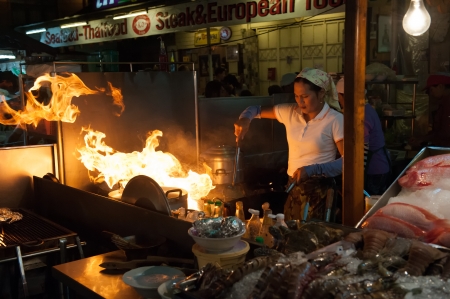 Hua Hin, Thailand  January 23, 2009  Thai boygirl chef woks a dish at the night market in Hua Hin  The famous night market in Hua Hin is a major tourist attraction  のeditorial素材
