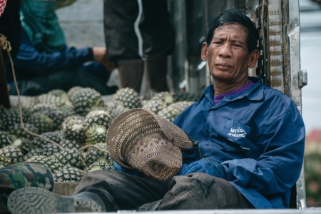 Hua Hin, Thailand  February 17, 2013    A tired farmworker rests on a truck bed with pineapples in Pranburi south of Hua Hin  Thailand is the world s largest pineapple producer のeditorial素材