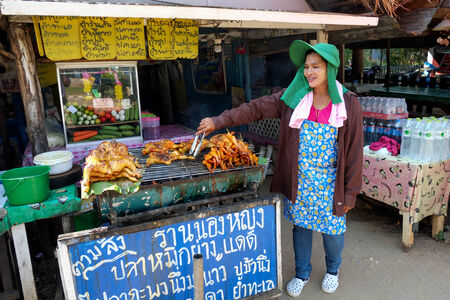 Hua Hin, Thailand  March 2, 2013 Proud Thai woman displays grilled chicken in Khao Kalok south of Hua Hin  Hua Hin is a major tourist destination renown for it s food のeditorial素材