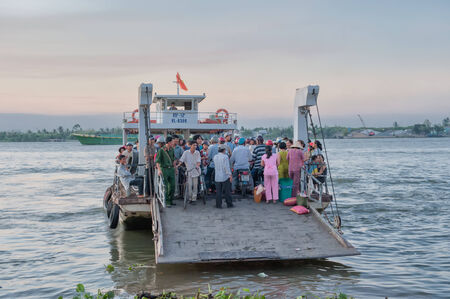 Vinh Long, Vietnam - March 6, 2009  A crowded ferry crosses one of the Mekong river tribituaries...