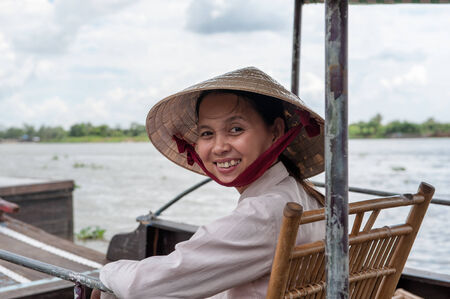 Vinh Long, Vietnam - March 7, 2009  Vietnamese woman sitting in a traditional boat in the Mekong delta near Vinh Long The Mekong river is a major route for transportation in Southeast Asia のeditorial素材