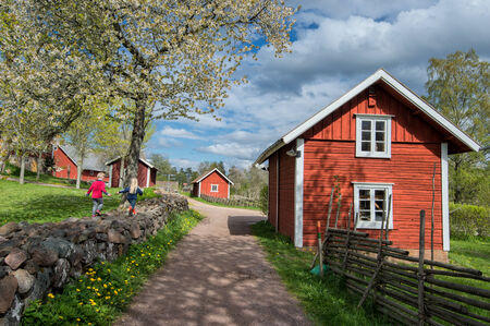 Haurida, Sweden  May 10, 2014  Kids play on a traditional stone wall at springtime in Asens by, Haurida, Sweden   Asens by is a typical example of rural Sweden hundred years ago のeditorial素材