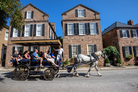Charleston, SC, USA - October 13, 2014: Horse carriage with tourists enjoying the facades of Societe Francaise and historic traditional residential architecture in Charleston, SC.のeditorial素材