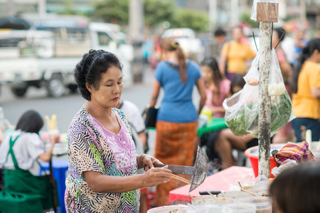 Yangon, Myanmar - February 5, 2014: Burmese woman cooking street food in Chinatown. Myanmar is ethnically diverse with 51 million inhabitants belonging to 135 ethnic groups.のeditorial素材