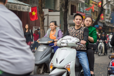 Hanoi, Vietnam - February 15, 2015: Young family on a motorbike in Hanoi. There are approximately four million motorbikes on the streets of Hanoi.のeditorial素材