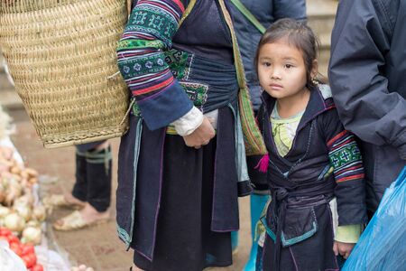 Sapa, Vietnam - February 13, 2015: Hmong child at a market in Sapa. Sapa is famous for its rugged scenery and its rich cultural diversity. Hmong people is one of many  colorful tribes.のeditorial素材
