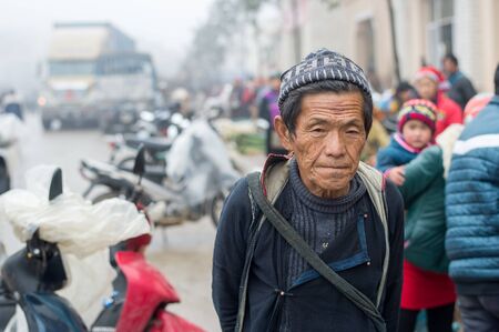 Sapa, Vietnam - February 13, 2015: Hmong man at a market in Sapa. Sapa is famous for its rugged scenery and its rich cultural diversity. Hmong people is one of many  colorful tribes.のeditorial素材