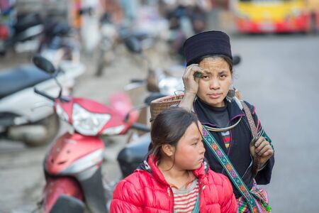 Sapa, Vietnam - February 15, 2015: Hmong woman on a street in Sapa. Sapa is famous for its rugged scenery and its rich cultural diversity. Hmong people is one of many  colorful tribes.のeditorial素材