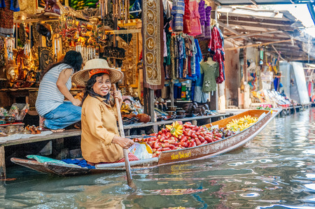 Damnoen Saduak, Thailand - February 2, 2009: Thai woman sells fruit from a boat at the Floating Market in Damnoen Saduak. The floating market is a major tourist attraction.のeditorial素材