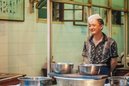 Xian China   July 3 2012: Hui muslim prepares street food at famous Muslim Street in Xian. Hui people are a Muslim ethnic minority in Xian and run a lively market at Muslim Street.のeditorial素材