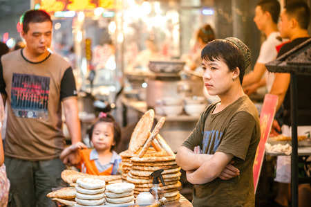 Xian China  July 3 2012: Hui muslim sells street food at famous Muslim Street in Xian. Hui people are a Muslim ethnic minority in Xian and run a lively market at Muslim Street.のeditorial素材