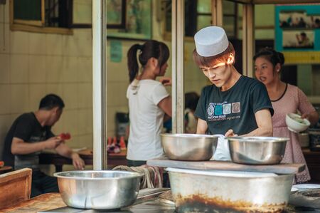 Xian China   June 20 2012: Hui muslim prepares street food at famous Muslim Street in Xian. Hui people are a Muslim ethnic minority in Xian and run a lively market at Muslim Street.のeditorial素材