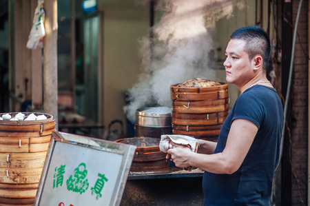 Xian China   June 20 2012: Hui man steams dumplings at famous Muslim Street in Xian. Hui people are a Muslim ethnic minority in Xian and run a lively market at Muslim Street.のeditorial素材