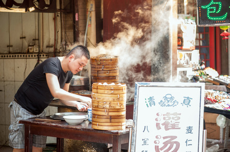 Xian China   June 20 2012: Hui man steams dumplings at famous Muslim Street in Xian. Hui people are a Muslim ethnic minority in Xian and run a lively market at Muslim Street.のeditorial素材