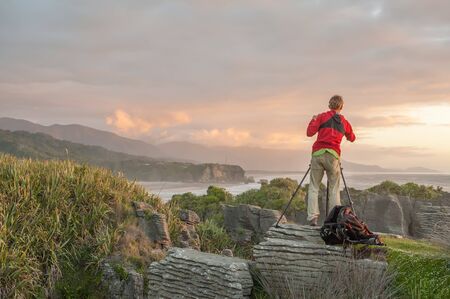 Punakaiki, New Zealand - February 11, 2012: Photographer captures the sunset at Pancake Rocks in Punakaiki. These limestone rocks on the west coast of South Island have become a major tourist attraction.のeditorial素材