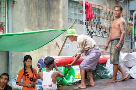 Yangon, Myanmar - February 10, 2014: Burmese people off-load a truck in Chinatown. Myanmar is ethnically diverse with 51 million inhabitants belonging to 135 ethnic groups.のeditorial素材