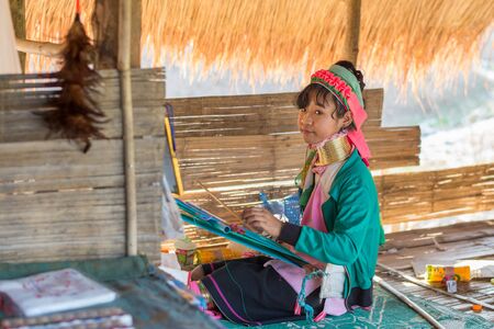 Chiang Rai, Thailand - February 4, 2016: Karen long neck girl weaving  in a village between Chiang Rai and Chiang Mai. Karen is one of several ethnic hill tribes in northern Thailandのeditorial素材