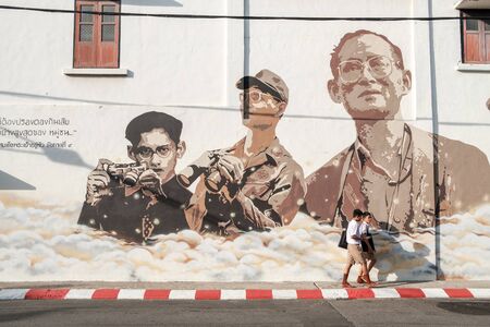 Phuket, Thailand - February 22, 2017: Thai schoolboys in Phuket Old Town pass a mural in remembrance of King Bhumibol Adulyadej.  As Thailand mourn the king signs of remembrance of the king are visible all over the country.のeditorial素材
