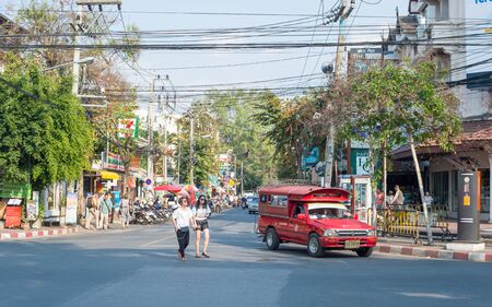 Chiang Mai, Thailand - February 6, 2016: Traditional red songthaew driving on a street in Chiang Mai. This is the largest city in northern Thailand.のeditorial素材