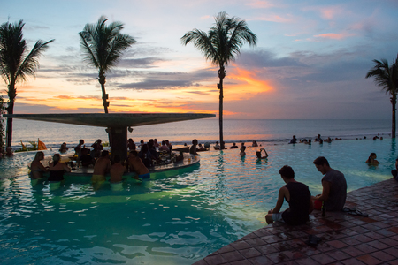 Bali, Indonesia - February 4, 2013: Tourists enjoy a Bali vacation by the pool and beach. Bali is popular tourist destination in particular for Australian people.のeditorial素材
