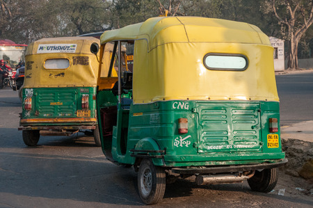New Dehli, India - February 1, 2011: Traditional tuktuks in New Dehli. The green and yellow tuktuks...
