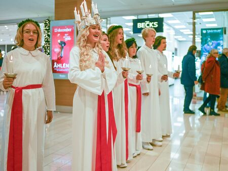 Norrkoping, Sweden - December 13, 2019: Traditional celebration of Saint Lucy in Sweden. Norrkopingâs Lucia 2019 Izabella Swartz singing Christmas carols in shopping mall Linden.のeditorial素材