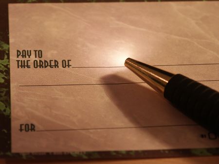 A check and pen with small highlightの写真素材