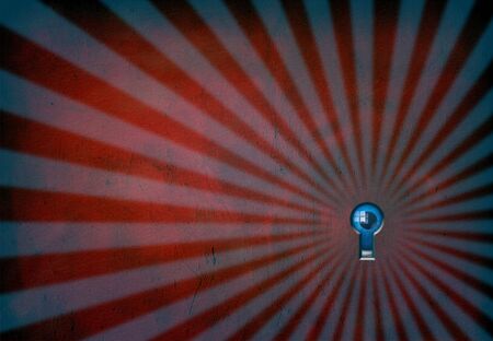 Eye peers through keyholeの写真素材