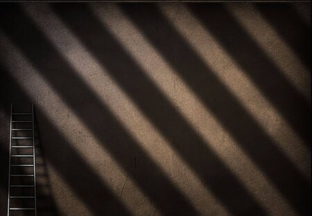 Ladder sits against empty wallの写真素材