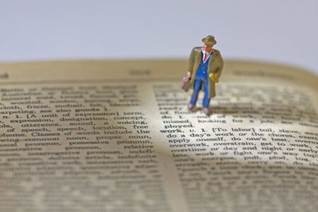 Tiny figure stands near text workの写真素材