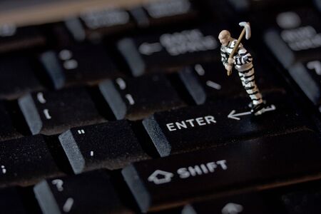 Criminal with pick axe on keyboardの写真素材