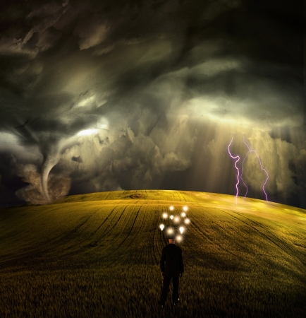 Man has many ideas in stormy fieldの写真素材