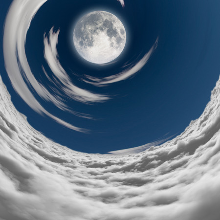 big full moon in a vortex of cloudsの写真素材