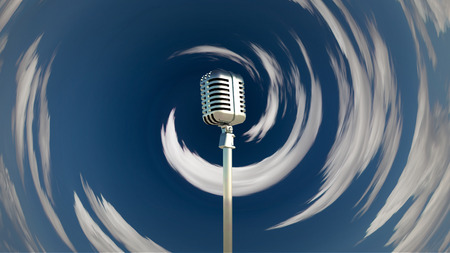 Classic microphone in cloudy skyの写真素材