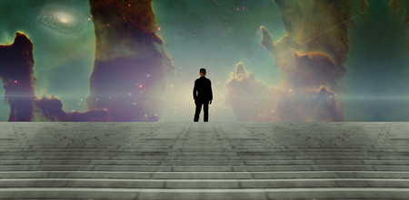Surreal scene. Man in black suit. Nebula and galaxy in the skyの写真素材